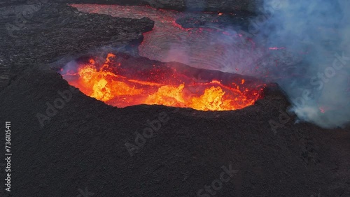 Aerial drone fly view over active volcanic crater eruption. Hot lava and magma coming out of the crater. Tourist attraction in Iceland Litlihrutur eruption 2023. Beautiful and dangerous disaster. photo