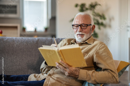 Tea, mature man and reading book in home on living room sofa. Happy, novel and Caucasian person in lounge to relax, study and knowledge of fantasy story in retirement hobby in house.