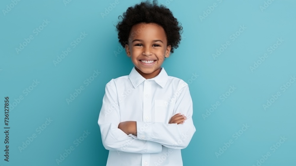 Portrait of adorable black little boy in shirt posing with folded arms and smiling over blue background, copy space. African american male child standing in studio Portrait of adorable black little boy in shirt posing with folded arms and smiling over blue background, copy space. African american male child standing in studio