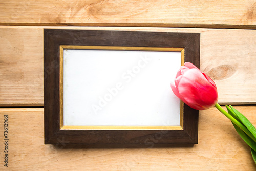 Red and white tulips and mockup photo frame on wooden background