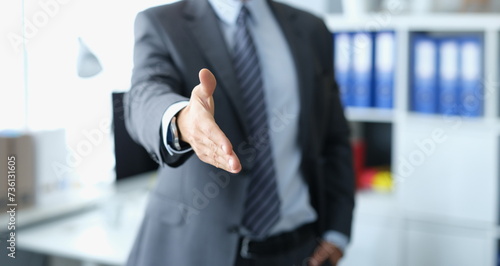 Man in business suit stretching out his hand for handshake closeup. Working with partners concept