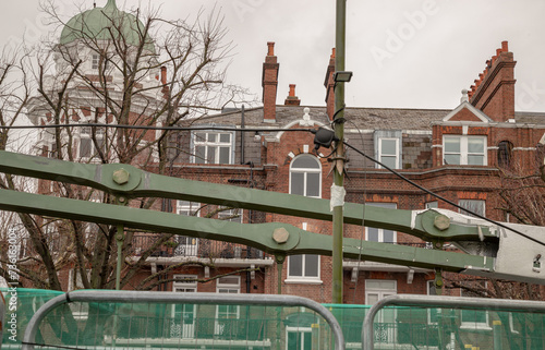 Structure of Hammersmith Bridge with old building background. One of the world's oldest suspension bridges and a major river crossing and primary route in west london, Space for text, Selective focus. photo