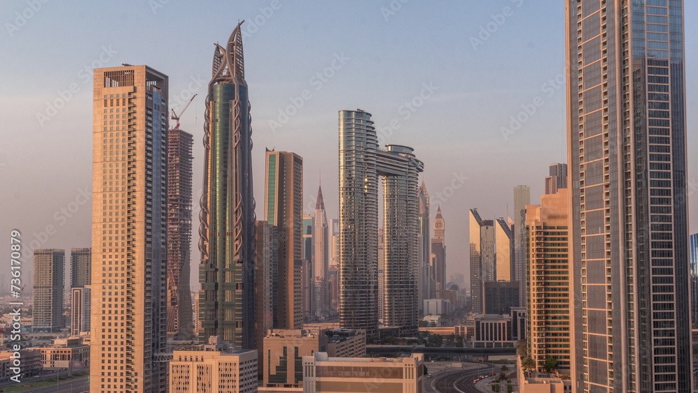 Many towers and skyscrapers with traffic on streets in Dubai Downtown and financial district all day timelapse.