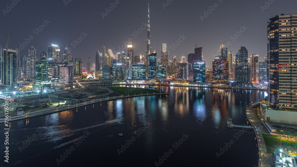 Fototapeta premium Aerial view to Dubai Business Bay and Downtown with the various skyscrapers and towers day to night timelapse