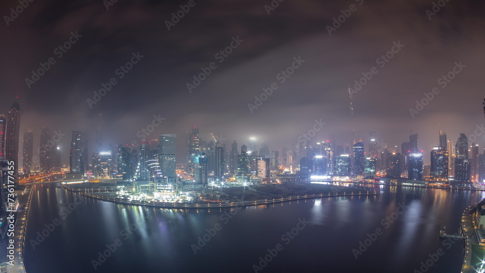 Aerial view to Dubai Business Bay and Downtown with the various skyscrapers and towers night timelapse