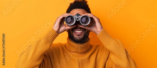 Exploring adventurer bearded man looking through binoculars in the wilderness photo