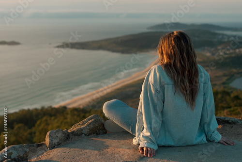 Young girl sitting on the Monteventoso viewpoint in Doniños, Ferrol.