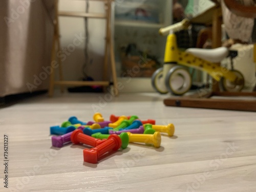 small figures are scattered on the floor in the children's room. children's room in kindergarten. Raising children through educational toys. Multi-colored figures from the designer on the floor.
