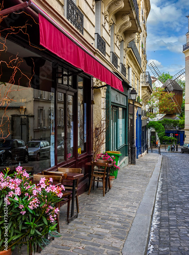 Cozy street with tables of cafe in quarter Montmartre in Paris, France. Cozy cityscape of Paris. Architecture and landmarks of Paris.
