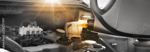 Pouring motor oil into car engine, color accent effect. Banner design photo