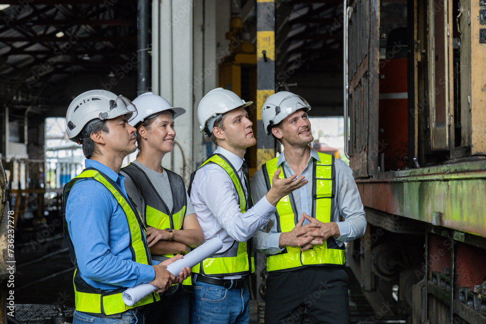 Chief engineer consults and analyzes train diesel engine problems Railway tracks in a train depot