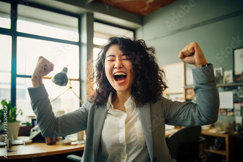 Korean woman laughing with showing victory with joy with a fist pump in the air photo