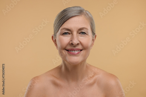 Beautiful woman with healthy skin on beige background