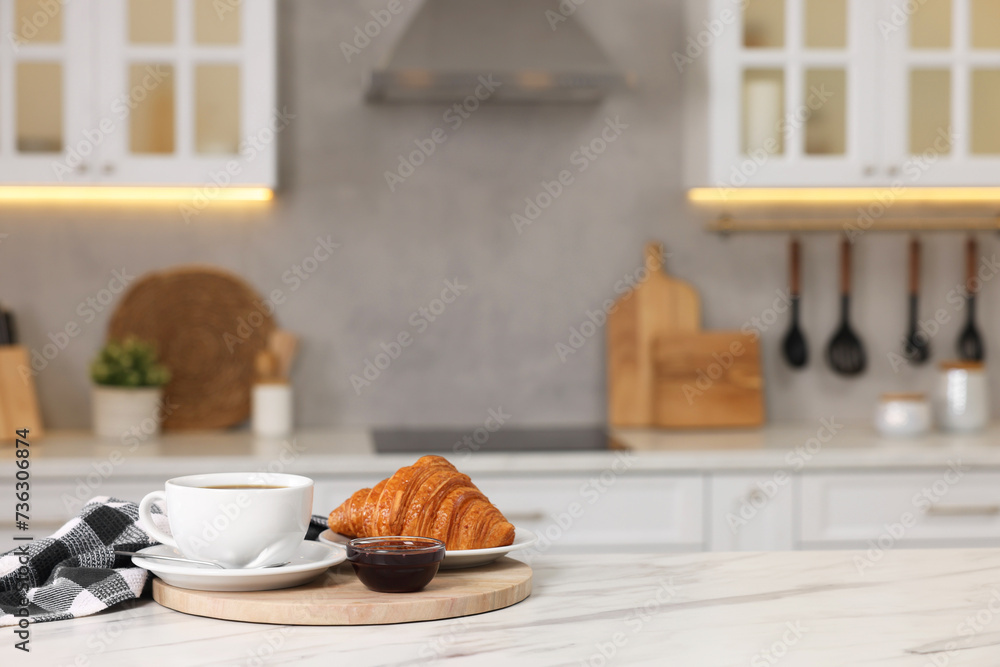 Breakfast served in kitchen. Fresh croissant, coffee, and jam on white table. Space for text Breakfast served in kitchen. Fresh croissant, coffee, and jam on white table. Space for text