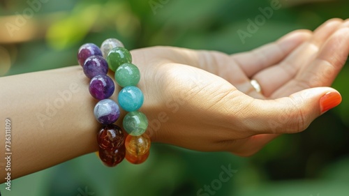 wrist is decorated with a chakra bracelet made of a semi-precious stone of a gentle color, symbolizing balance and well-being © Anna