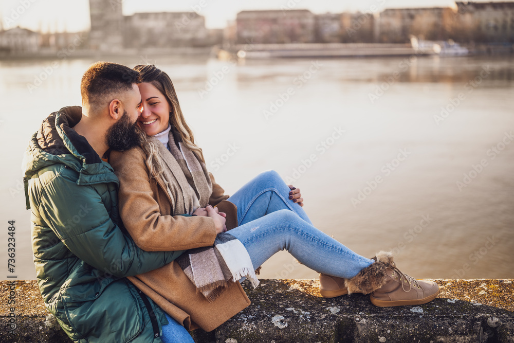 Happy couple embracing while  enjoy sitting by the river.