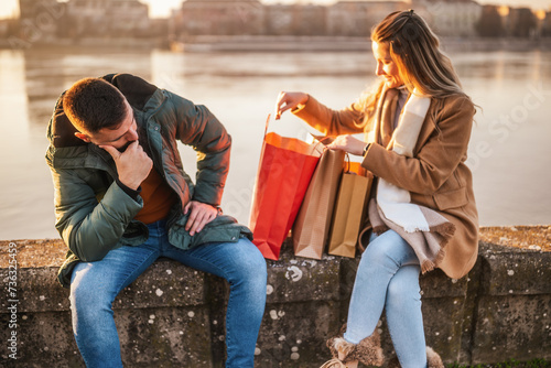 Husband is  angry because his wife has spent too much money on shopping.
