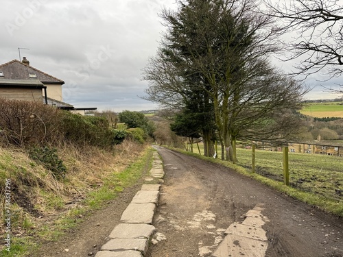 Winter scene, with a rocky dirt road, trees, fields, and distant hills on, Lower Bankhouse, Pudsey, Yorkshire, UK photo