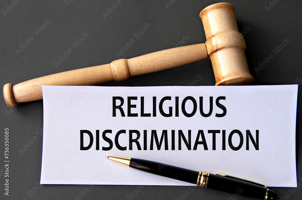 RELIGIOUS DISCRIMINATION - words on white paper on dark background with judge's gavel