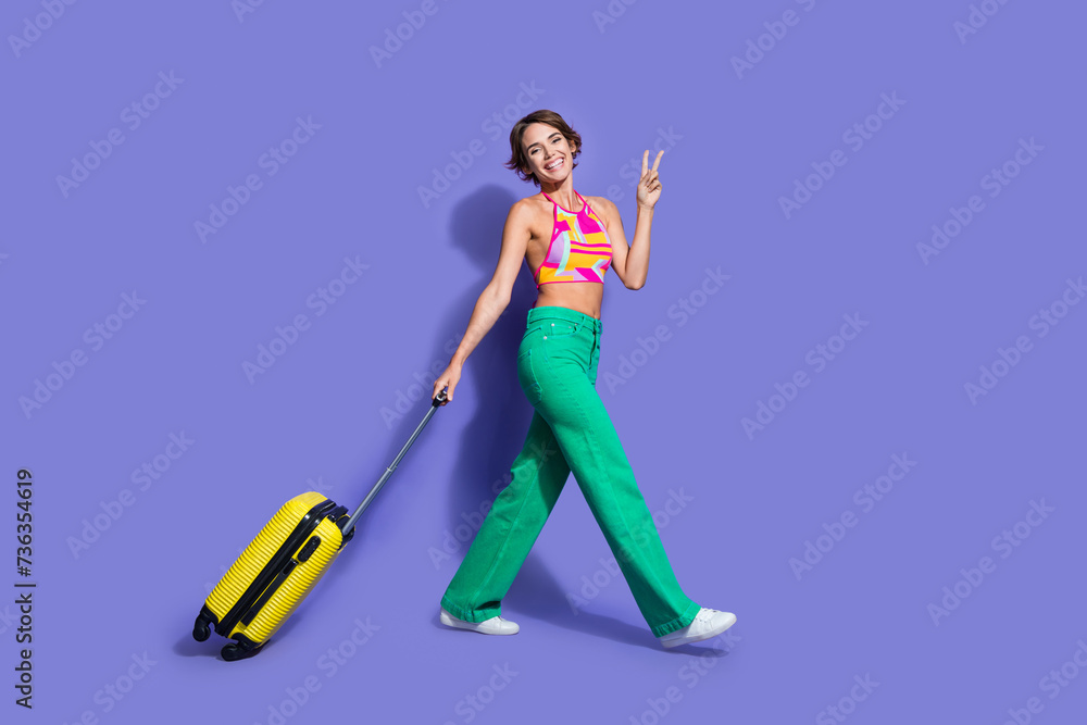Photo of cheerful cute good mood girl wear trendy clothes go airport fly abroad sea resort vacation isolated on purple color background Photo of cheerful cute good mood girl wear trendy clothes go airport fly abroad sea resort vacation isolated on purple color background