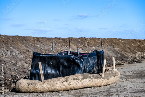 Filter sock staked around a storm intake at a construction site photo