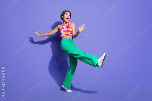 Full length photo of overjoyed lovely girl wear bright outfit celebrate festive event look empty space isolated on purple color background