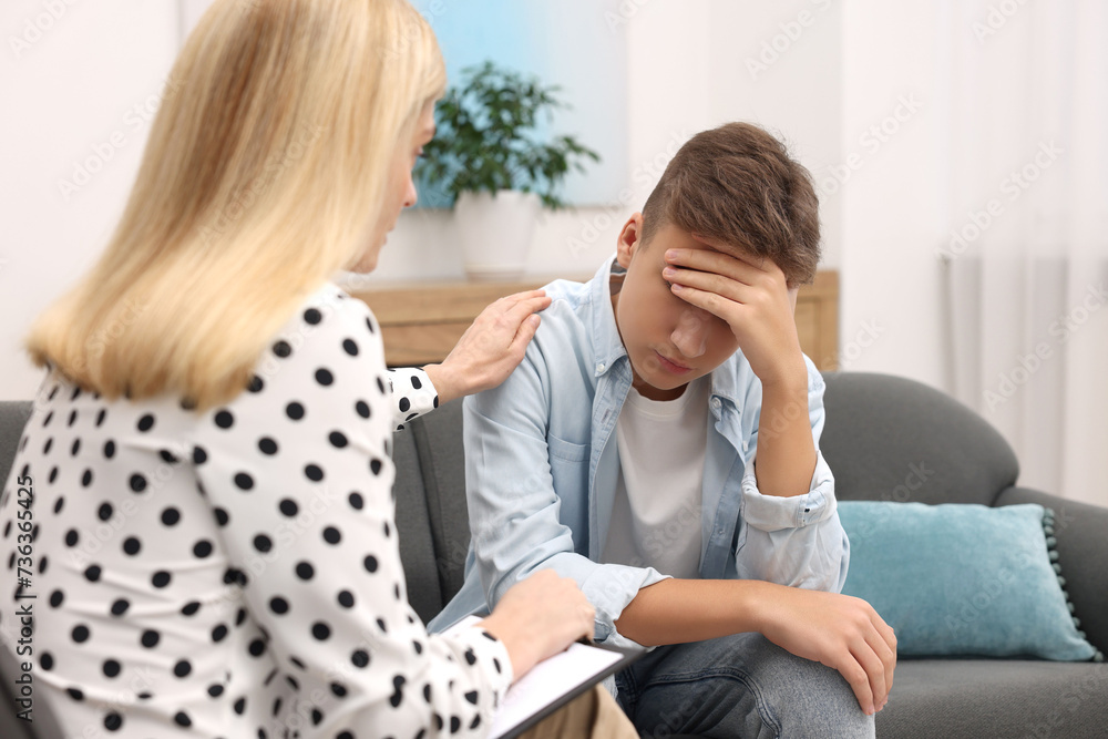 Obraz premium Psychologist working with teenage boy in office