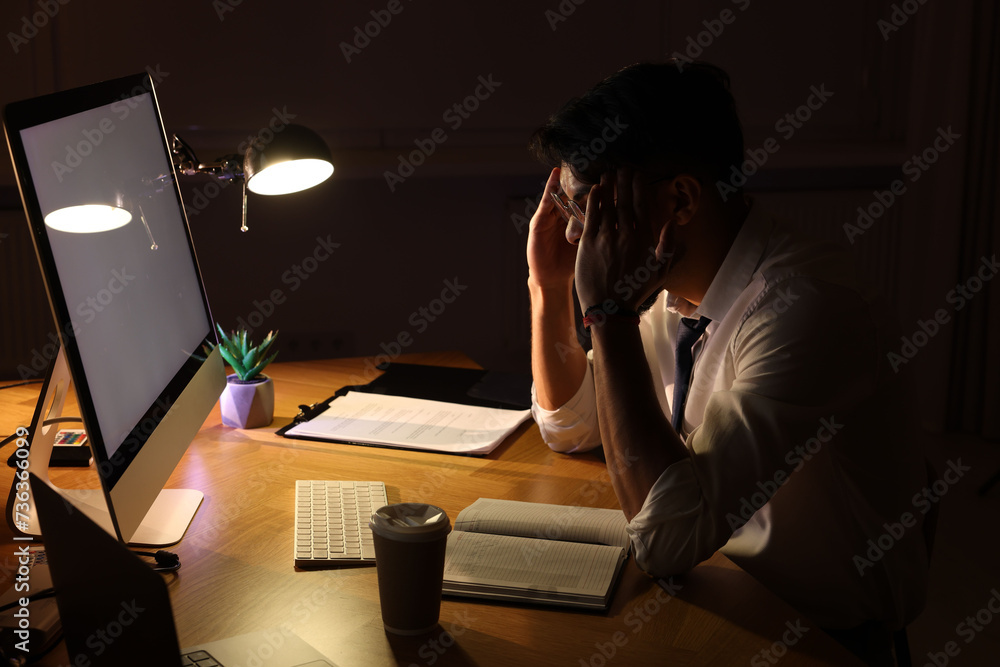 Tired young man working late in office Tired young man working late in office