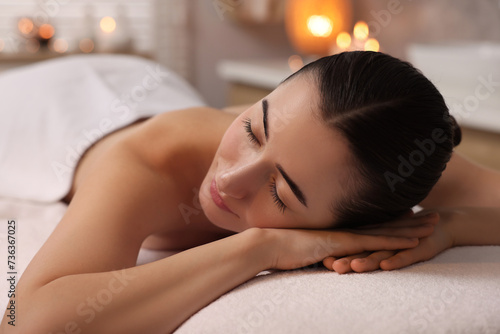 Beautiful woman relaxing on massage couch in spa salon