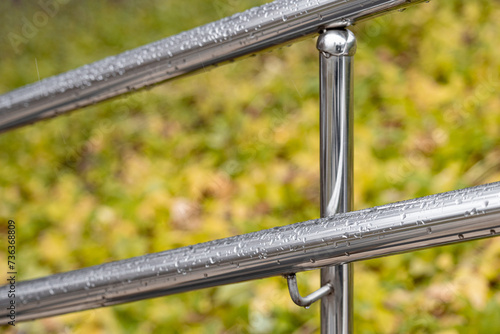 metal handrail with raindrops, shot with shallow depth of field.