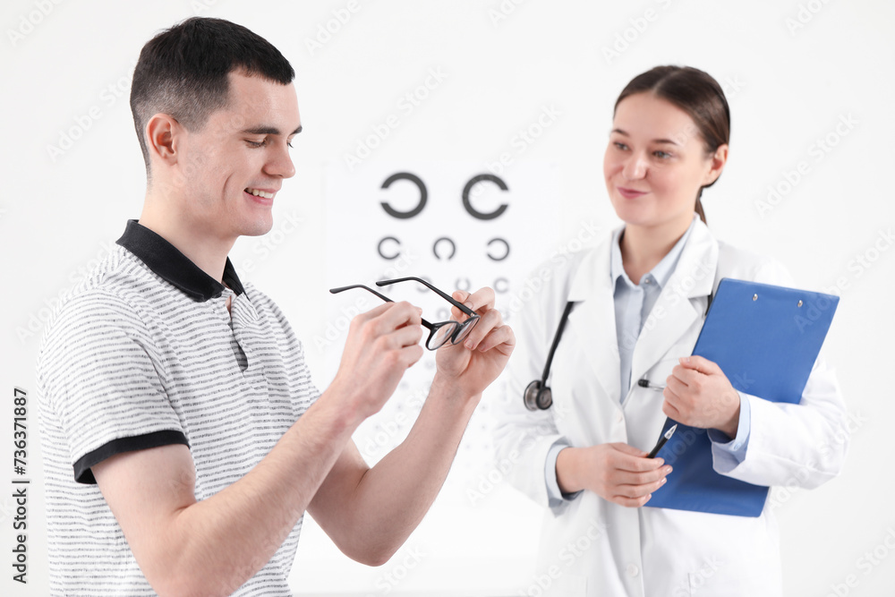 Vision testing. Young man trying glasses at ophthalmologist office Vision testing. Young man trying glasses at ophthalmologist office