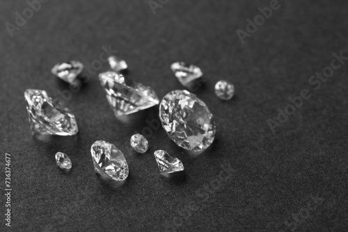 Beautiful shiny diamonds on gray table, closeup. Space for text