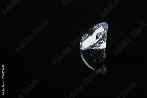 Beautiful shiny diamond on black mirror surface  space for text