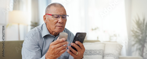 Phone, medicine and senior man with home research, reading label and learning of telehealth services. Online patient with pills bottle, tablet and mobile for information or health benefits on a sofa photo