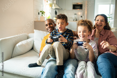 Family playing video games together in living room photo