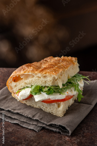 Wallpaper Mural Focaccia pizza filled with mozzarella, salad and tomatoes. Side view Torontodigital.ca