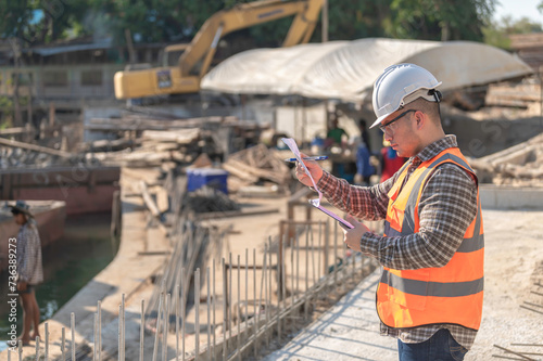 Construction engineer working on a bridge construction site over a river,Civil engineer supervising work,Foreman inspects work at a construction site