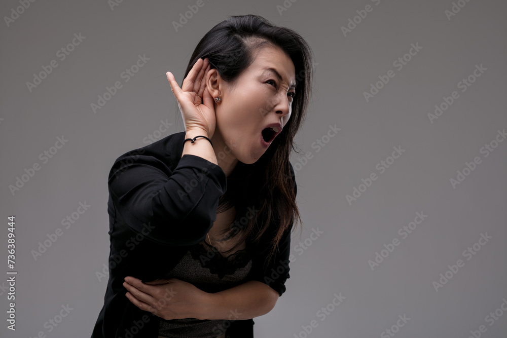 Naklejka premium Expresses hearing difficulty with a surprised grimace or what th