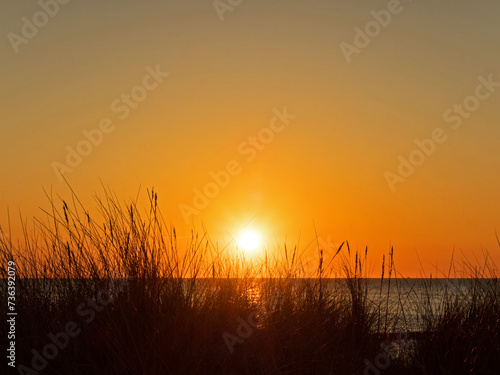 Blick durch die Dünen zur in der Ostsee versinkenden Sonne, Deutschland