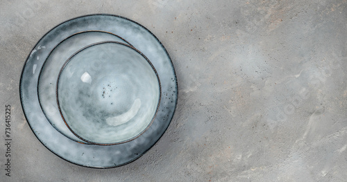 ceramic tableware, different size plate on gray background top view
