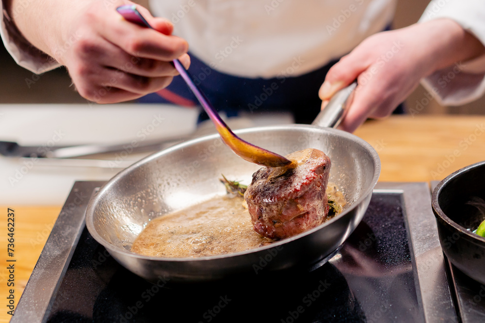 close-up of seared beef steak with rosemary topped with melted butter in frying pan