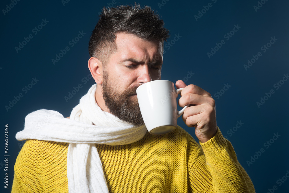 Bearded man enjoying cup of hot tea in cafe. Satisfied attractive man drinking hot beverage. Coffee break. Handsome male with beard and mustache in sweater and scarf with mug of coffee enjoys morning. Bearded man enjoying cup of hot tea in cafe. Satisfied attractive man drinking hot beverage. Coffee break. Handsome male with beard and mustache in sweater and scarf with mug of coffee enjoys morning.