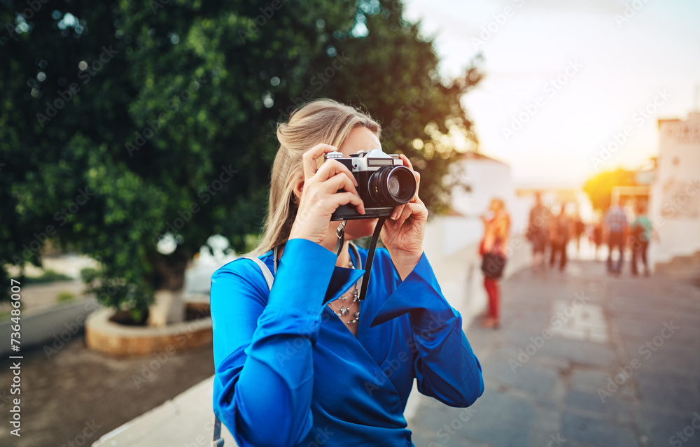 A woman tourist takes photographs of the sights in the old town.
