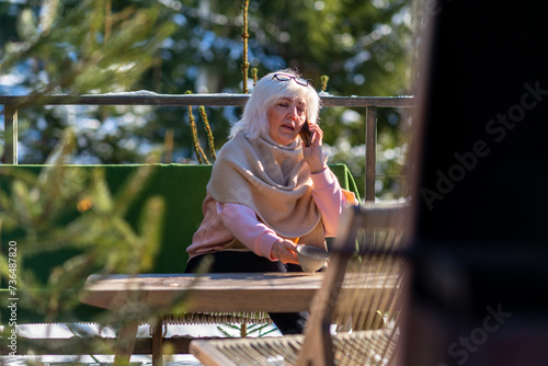 Woman talking on the phone while sitting on the terrace