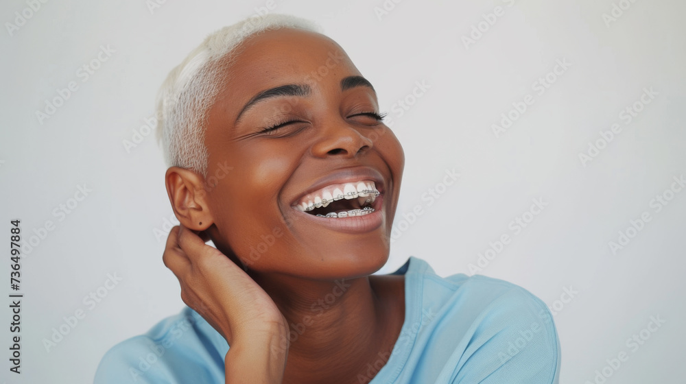 A joyous woman is laughing heartily, wearing a denim shirt and dental braces, showcasing a moment of pure happiness and exuberance. A joyous woman is laughing heartily, wearing a denim shirt and dental braces, showcasing a moment of pure happiness and exuberance.