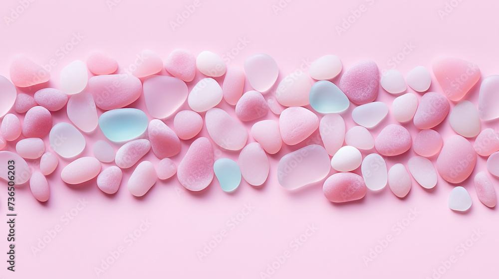 Polish textured sea glass and stones on pink background