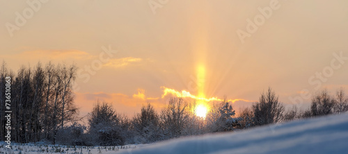 Kolorowy pomarańczowo złoty zachód słońca w zimowej scenerii wśród wzgórz w malowniczych okolicach Ostrowca. 
