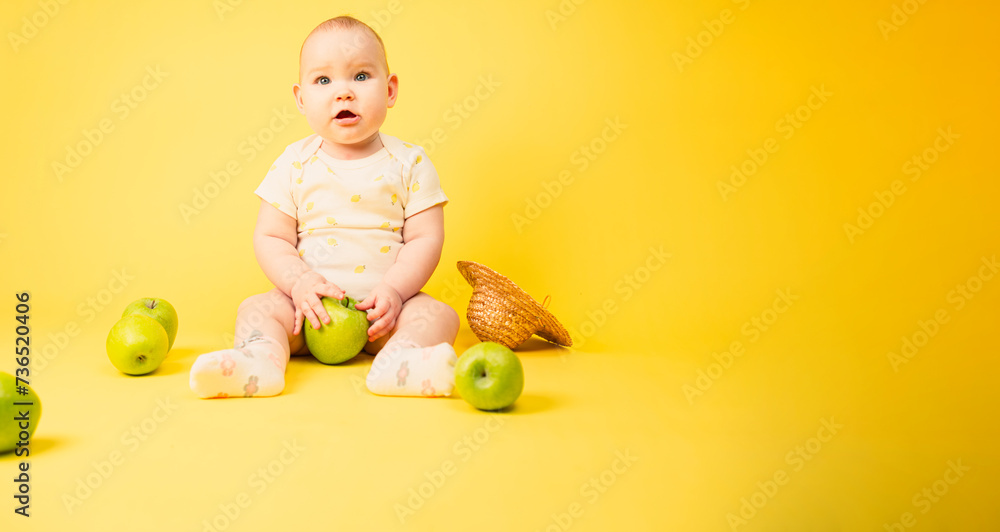 Cute baby girl with green apples sitting in studio on yellow background. Cute baby girl with green apples sitting in studio on yellow background.