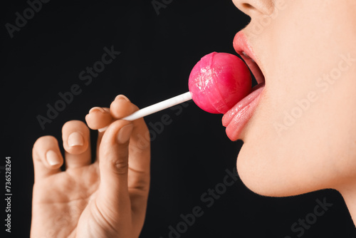 Young woman eating lollipop...
