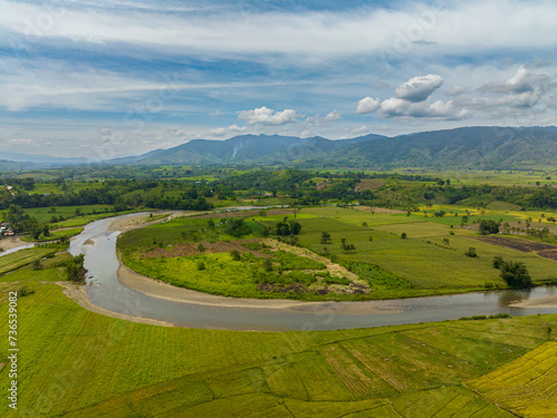 Rice fields, paddy farms and riverbanks. Blue sky and clouds. Mindanao, Philippines. © MARYGRACE
